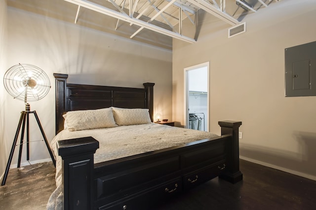 bedroom featuring electric panel, a spacious closet, and dark hardwood / wood-style floors