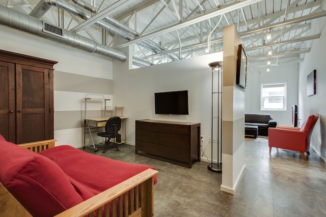 living room featuring concrete flooring and a high ceiling