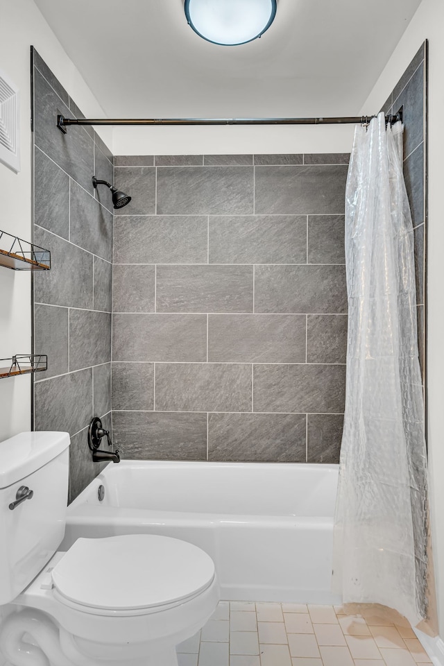 bathroom featuring tile patterned floors, toilet, and shower / bathtub combination with curtain