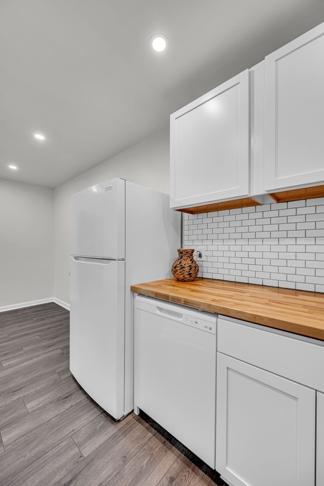 kitchen featuring butcher block countertops, light hardwood / wood-style floors, white cabinets, and white appliances