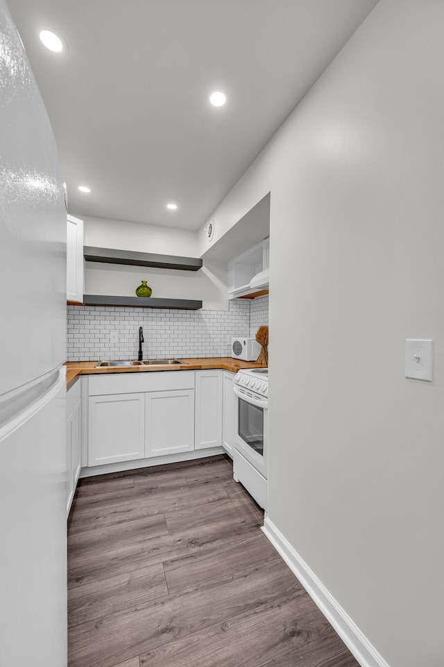 kitchen featuring butcher block counters, light wood-type flooring, white appliances, and white cabinetry