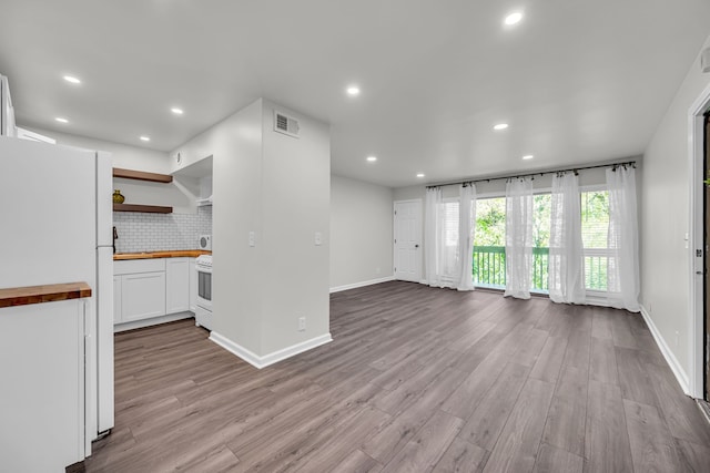 kitchen with wood counters, backsplash, white appliances, white cabinets, and light wood-type flooring