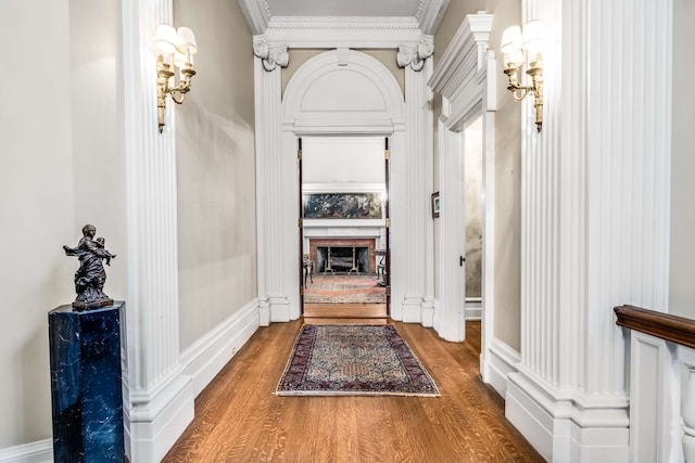 hall with wood-type flooring and crown molding