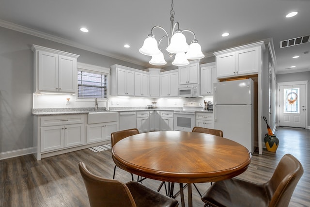 kitchen with white appliances, dark wood-type flooring, crown molding, hanging light fixtures, and white cabinetry