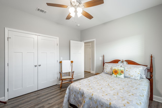 bedroom with ceiling fan, dark wood-type flooring, and a closet