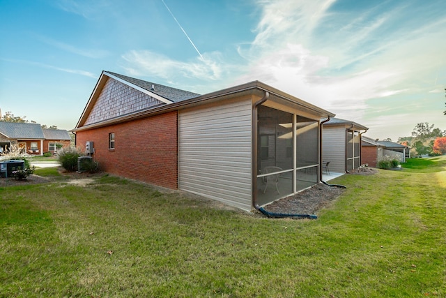 view of home's exterior featuring a yard and a sunroom