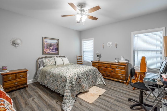 bedroom with dark hardwood / wood-style flooring, multiple windows, and ceiling fan