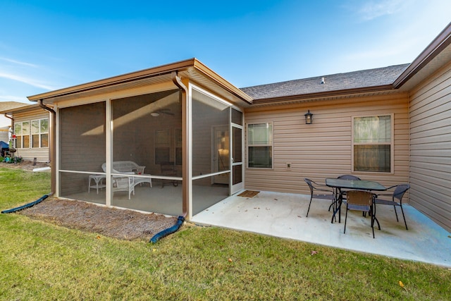 back of house with a lawn, a sunroom, and a patio