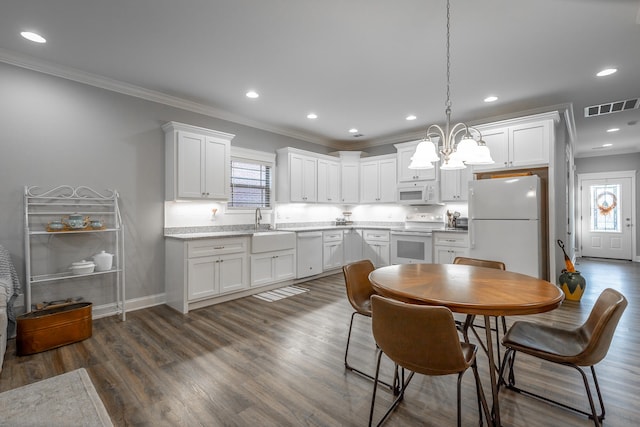 kitchen featuring white cabinetry, pendant lighting, and white appliances