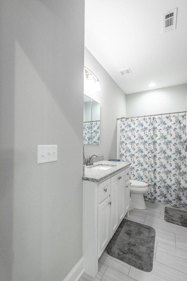 bathroom featuring vanity, curtained shower, and toilet