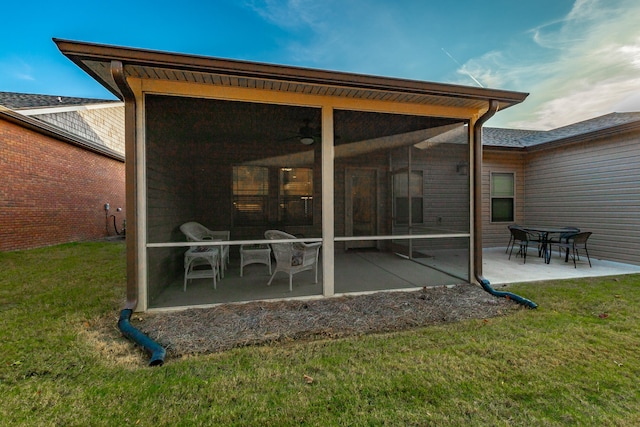 back of property featuring a lawn, a sunroom, and a patio area