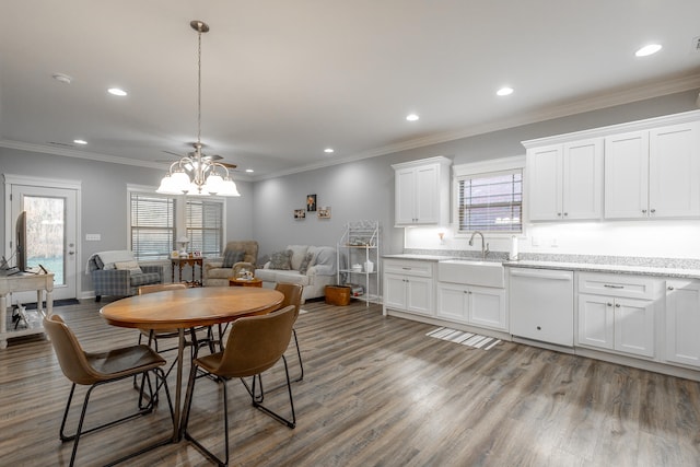 dining area with ceiling fan, crown molding, wood-type flooring, and sink