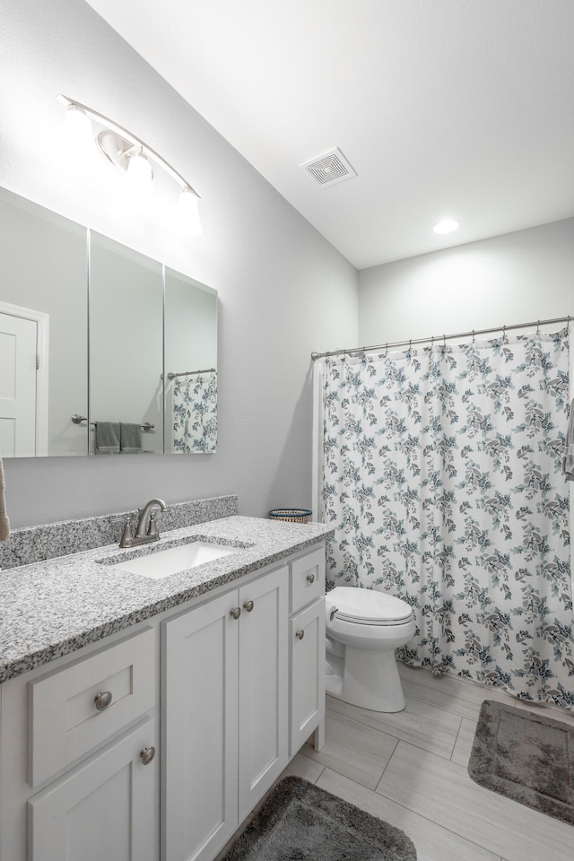 bathroom with vanity, toilet, and walk in shower