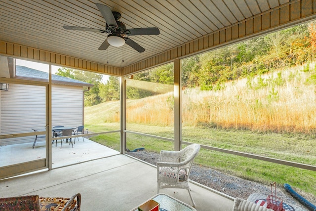 unfurnished sunroom with ceiling fan and wooden ceiling