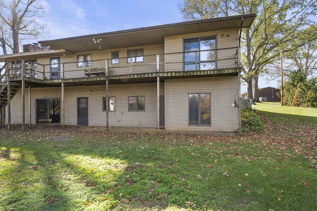 back of house featuring a yard, a balcony, and a wooden deck