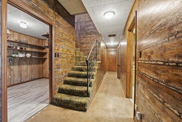 interior space featuring wood walls and concrete flooring