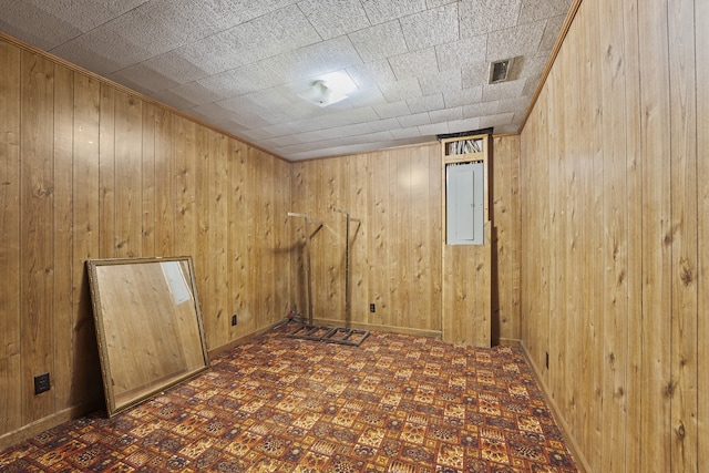 unfurnished room featuring electric panel and wooden walls