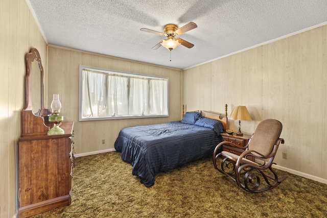 bedroom with dark colored carpet, ceiling fan, a textured ceiling, and wooden walls