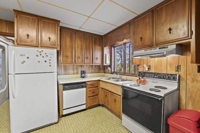 kitchen featuring a paneled ceiling, white appliances, and sink