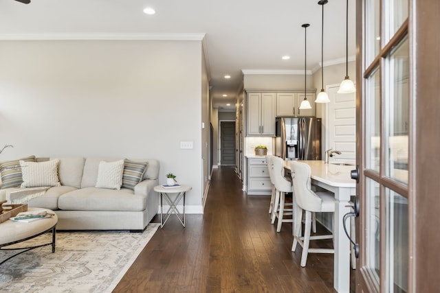 living room with dark wood-type flooring, ornamental molding, and sink