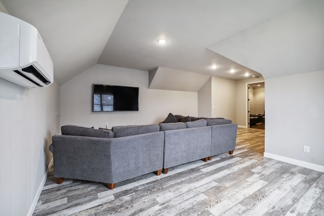 living room with vaulted ceiling, light hardwood / wood-style floors, and an AC wall unit