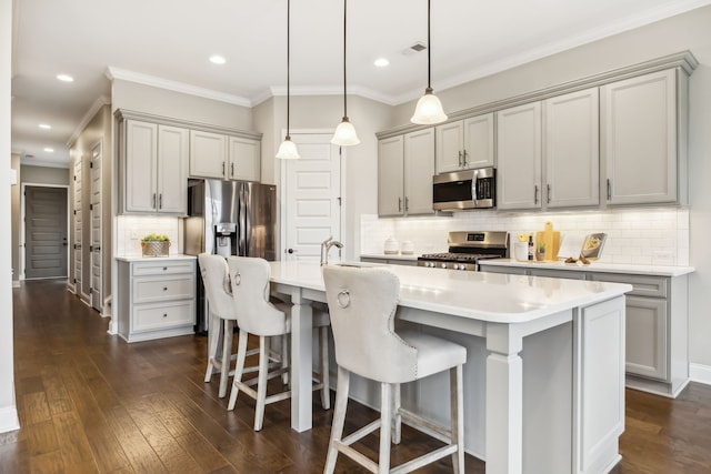 kitchen featuring gray cabinets, appliances with stainless steel finishes, and a kitchen island with sink