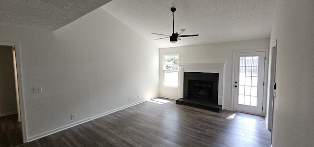 unfurnished living room with dark hardwood / wood-style floors, vaulted ceiling, a wealth of natural light, and ceiling fan