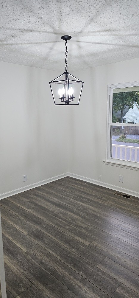 spare room with dark hardwood / wood-style flooring and a textured ceiling