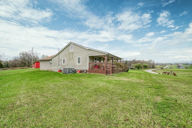 view of side of property featuring central air condition unit, a yard, and a porch