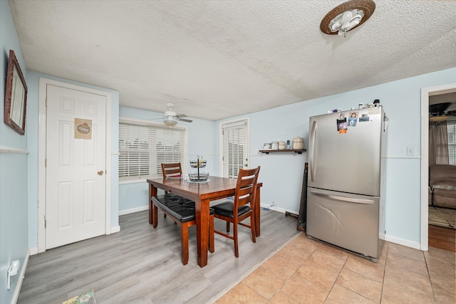 dining room with ceiling fan, light hardwood / wood-style floors, and a textured ceiling