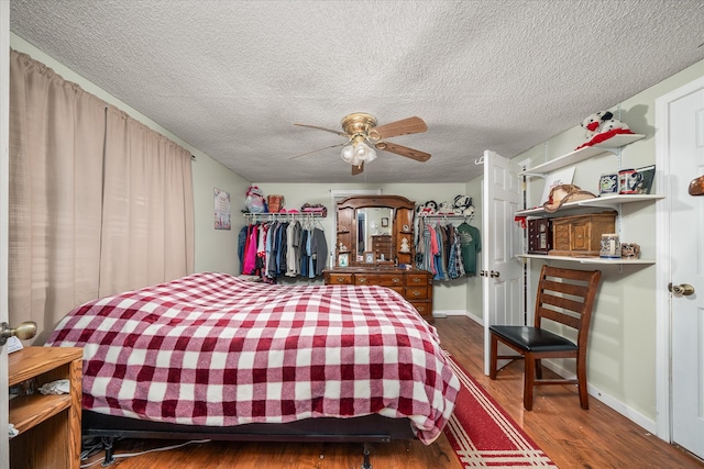 bedroom featuring a textured ceiling, ceiling fan, and dark wood-type flooring