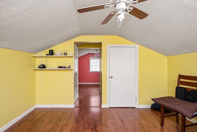 additional living space with a textured ceiling, hardwood / wood-style flooring, ceiling fan, and lofted ceiling