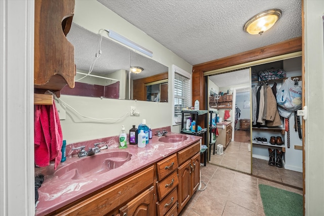 bathroom featuring tile patterned floors, vanity, and a textured ceiling