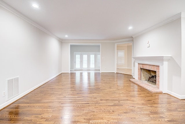 unfurnished living room with a fireplace, light wood-type flooring, and ornamental molding