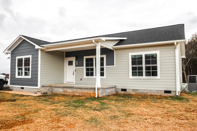 view of front of house with covered porch, central AC, and a front lawn