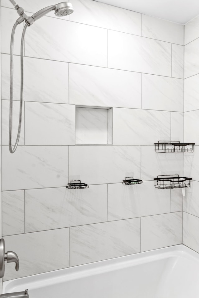 bathroom featuring tiled shower / bath