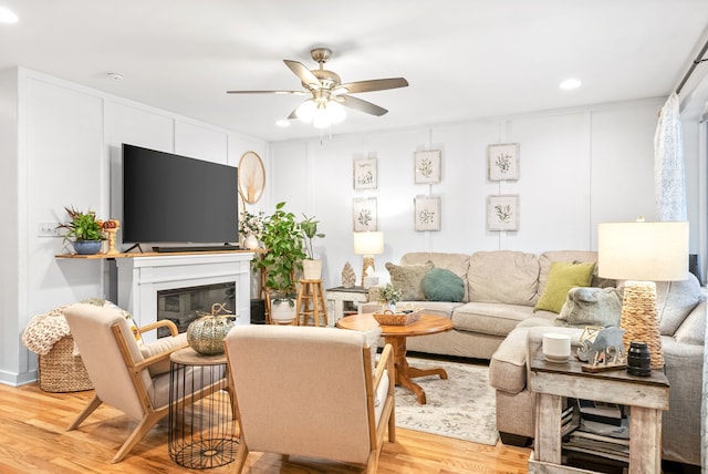 living room featuring ceiling fan and light hardwood / wood-style floors