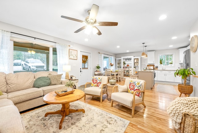 living room featuring light hardwood / wood-style flooring and ceiling fan