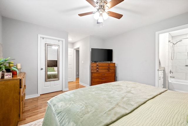 bedroom featuring ensuite bathroom, ceiling fan, and light wood-type flooring