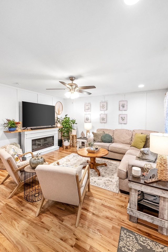 living room with light hardwood / wood-style flooring and ceiling fan