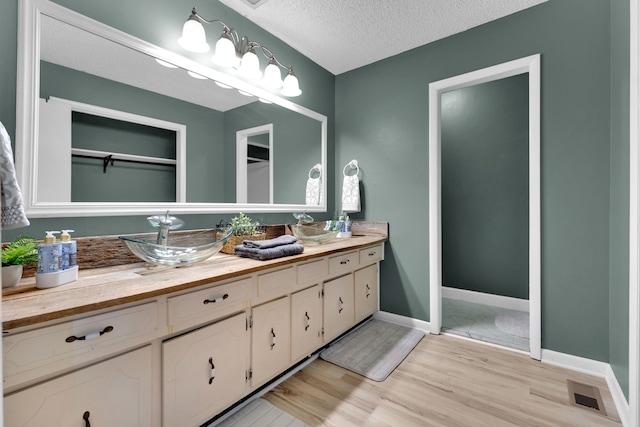 bathroom featuring vanity, a textured ceiling, and hardwood / wood-style flooring