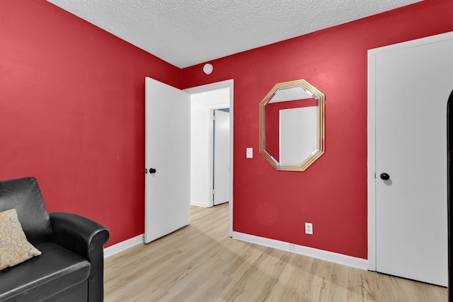 sitting room with a textured ceiling and light hardwood / wood-style flooring