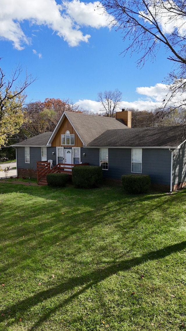 rear view of house featuring a lawn