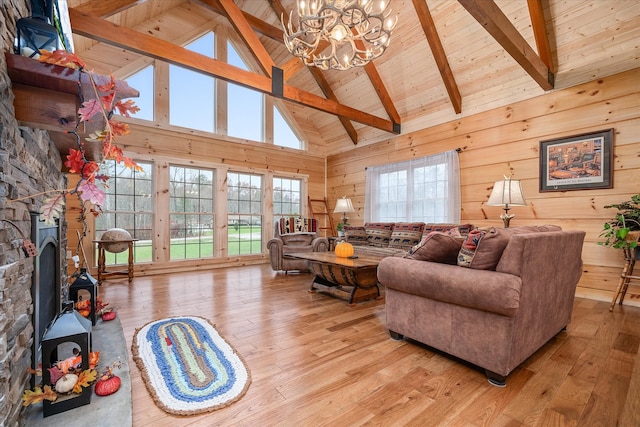 living room with plenty of natural light, high vaulted ceiling, and light wood-type flooring