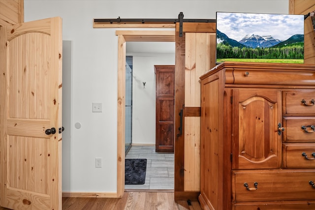 interior space with a barn door and light hardwood / wood-style floors