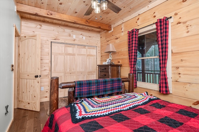 bedroom with ceiling fan, wooden ceiling, beamed ceiling, a closet, and hardwood / wood-style flooring