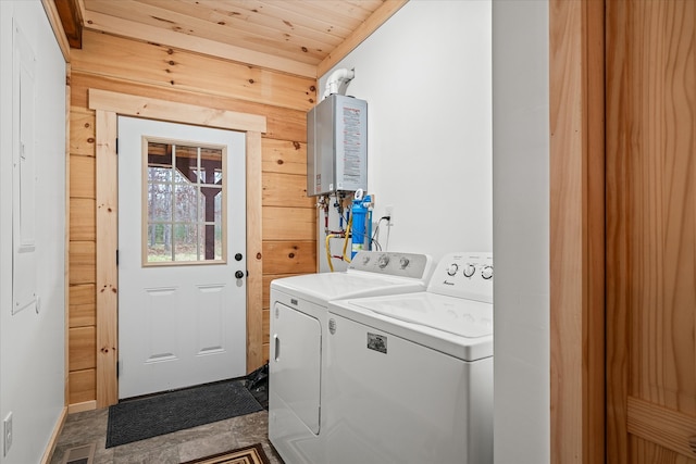 laundry area featuring separate washer and dryer, tankless water heater, wooden ceiling, and wood walls