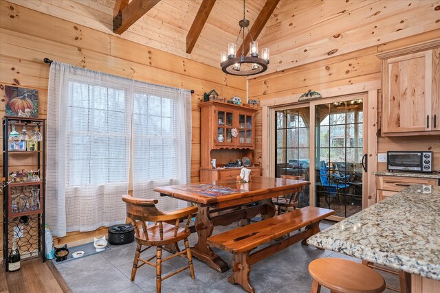 tiled dining room with wooden walls, wooden ceiling, lofted ceiling with beams, and a notable chandelier