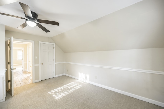 additional living space with ceiling fan, light carpet, and vaulted ceiling