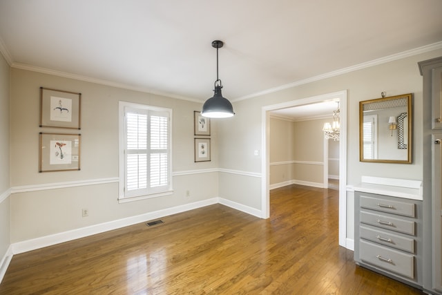 unfurnished dining area with an inviting chandelier, dark hardwood / wood-style flooring, and crown molding